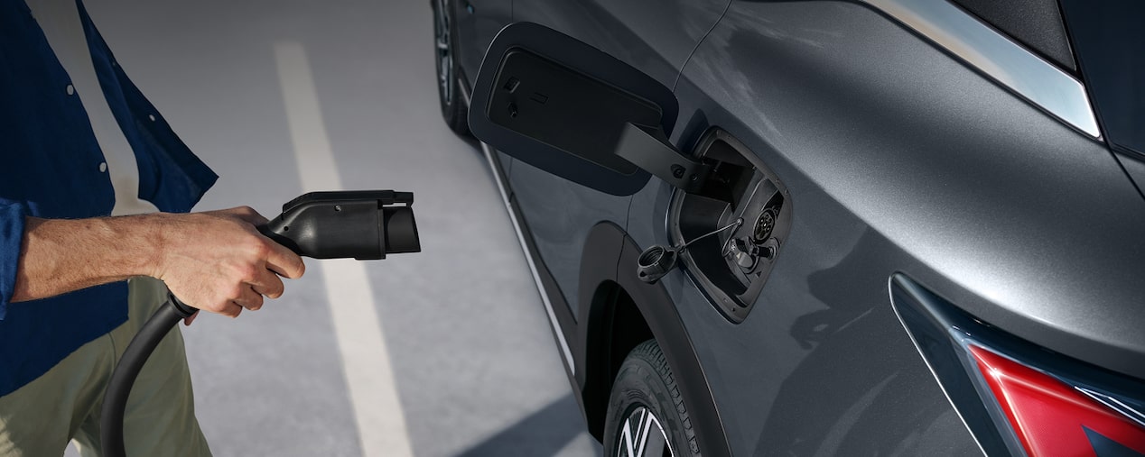 Detalhe do plug de um wall box prestes a ser conectado a um carro elétrico. Esta imagem ilustra a sessão de carregadores da linha de acessórios originais Chevrolet.