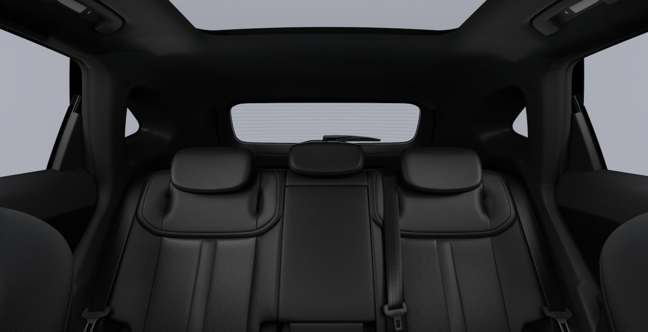 Interior do SUV Chevrolet Captiva EV visto dos bancos traseiros, mostrando assentos na cor jet black e teto solar panorâmico.