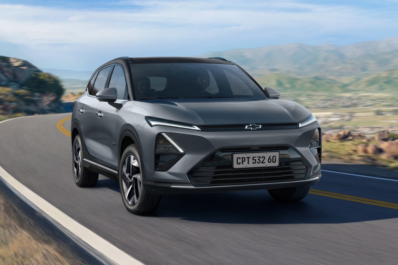 Chevrolet Captiva EV em movimento em uma estrada sinuosa cercada por montanhas e vegetação sob céu azul.