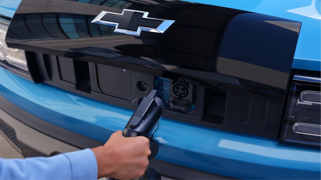 Mão masculina conectando o carregador wall box ao Chevrolet Spark EUV.