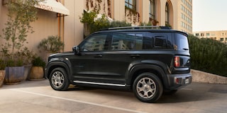 Spark EUV na cor Preto Rio Negro estacionado em frente a um edifício elegante.