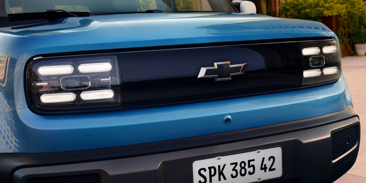 Close frontal do Spark EUV Azul Atlântico com faróis em LED e grade iluminada, reforçando a identidade visual moderna e imponente.