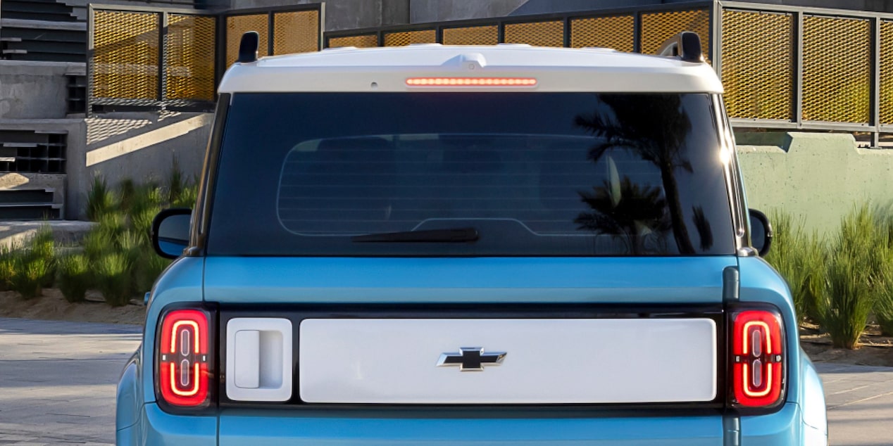 Vista traseira do Spark EUV Azul Atlântico com lanternas em LED acesas e logotipo Chevrolet centralizado, reforçando o estilo marcante do SUV.