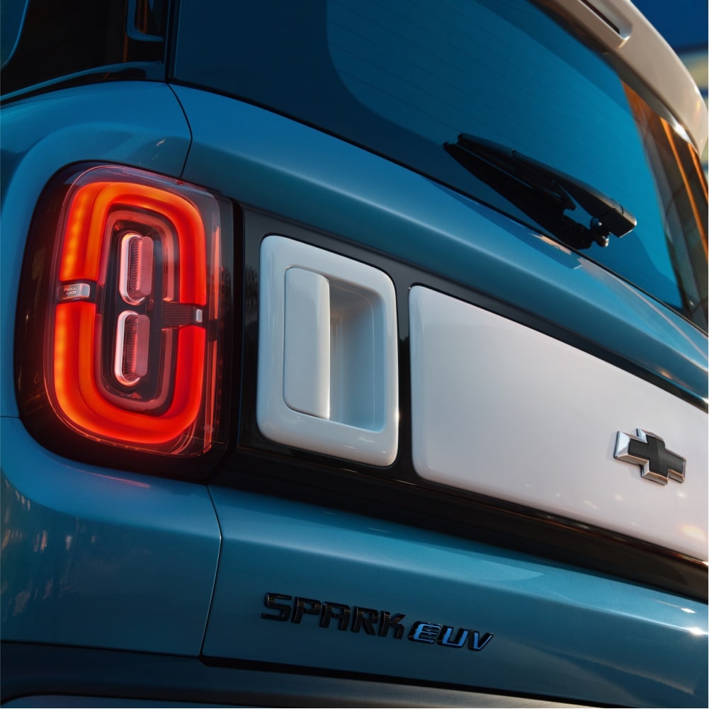 Close frontal do Spark EUV Azul Atlântico com faróis em LED e grade iluminada, reforçando a identidade visual moderna e imponente.