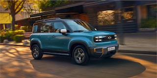 Spark EUV Azul Atlântico rodand por uma rua residencial, com faróis acesos e estilo marcante.