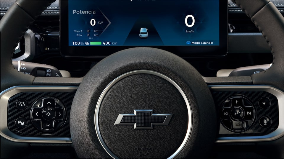 Close no painel de instrumentos digital e no volante com o logo Chevrolet ao centro, evidenciando a interface tecnológica do SUV elétrico.