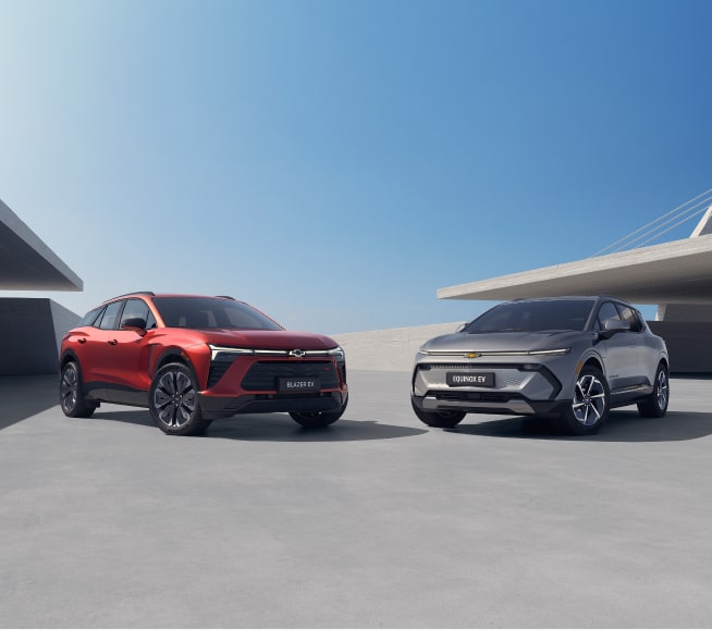 Banner predominantemente azul. À esquerda, um quadrante azul escuro com o logo GM Fleet no alto; abaixo, o texto: Assine seu Chevrolet - Dirigir um Chevrole 0 km com tudo incluso ficou mais simples. Com a assinatura GM Fleet, pessoas físicas e jurídicas contam com um pacote completo: seguro, IPVA, licenciamento e manutenção já estão resolvidos. E quando o contrato termina, é só trocar de carro e continuar rodando com praticidade, além do CTA (botão) de Sabia mais. À direita, um Blazer EV RS na cor vermelha e um Equinox EV na cor prata, em imagem ambientada.