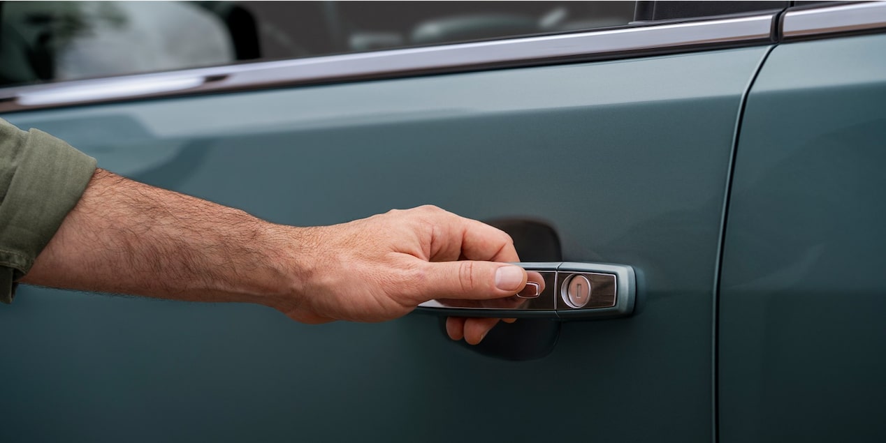 Homem com a mão na maçaneta de um Chevrolet