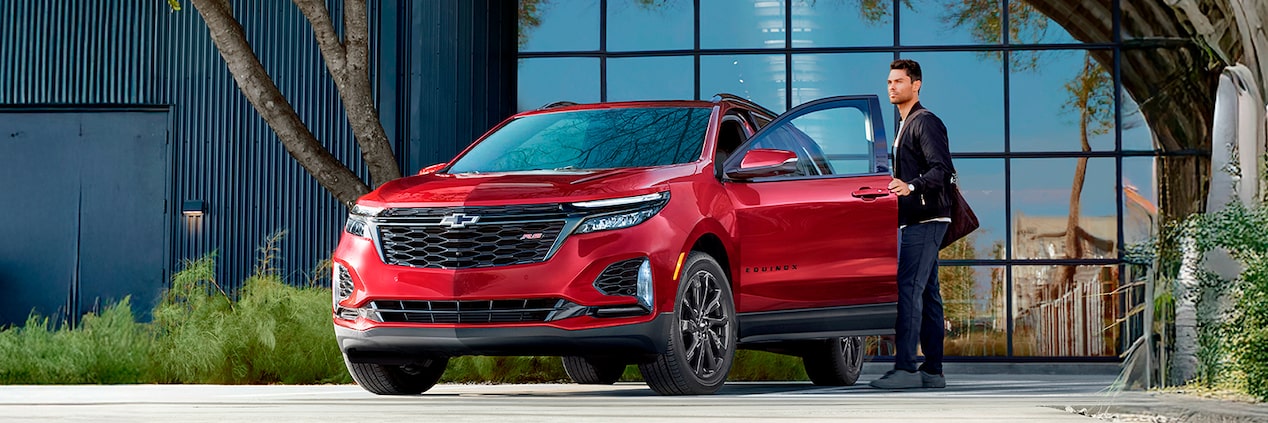 Homem abrindo a porta de um carro Chevrolet