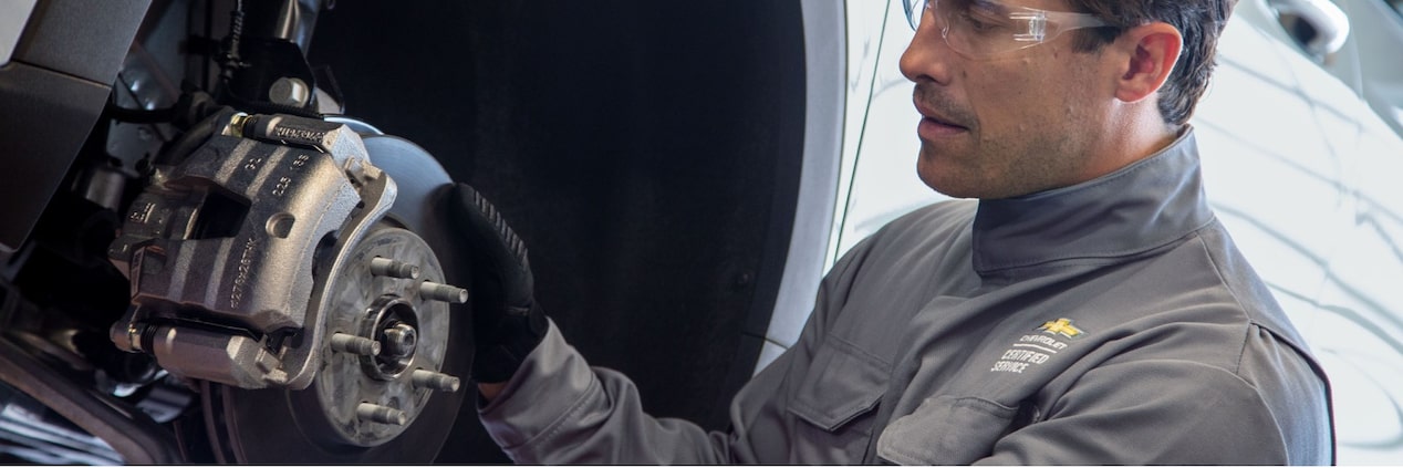 Homem fazendo a manutenção de um veículo Chevrolet