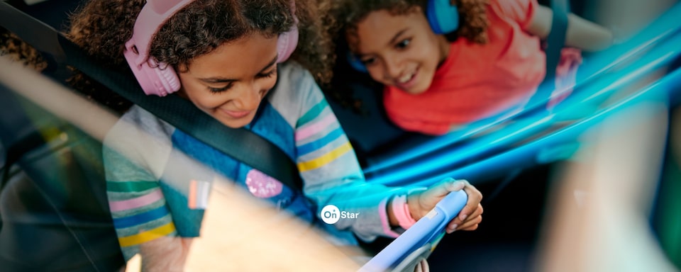 Duas crianças com fones de ouvido e um tablet