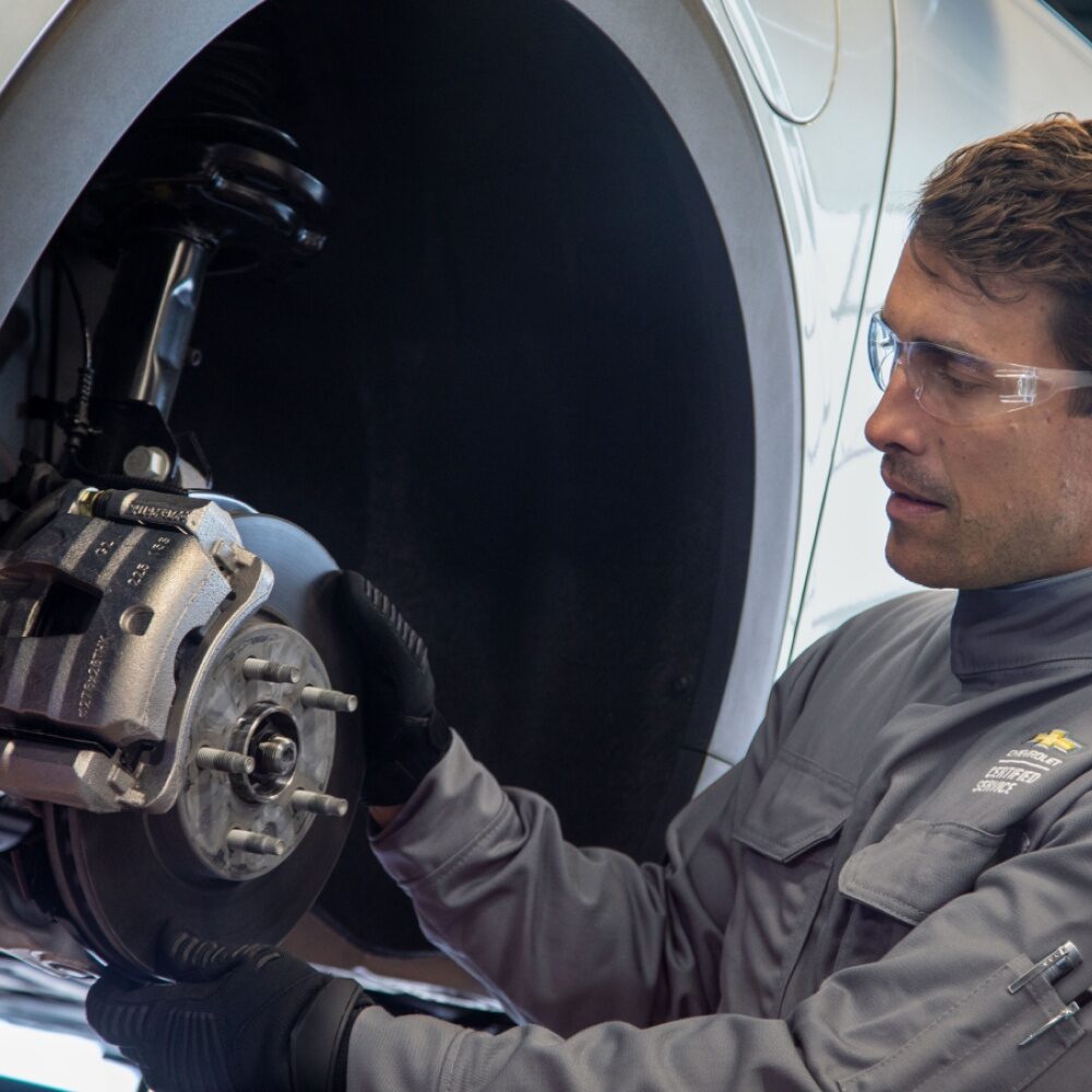 Homem fazendo a mecânica de um Chevrolet