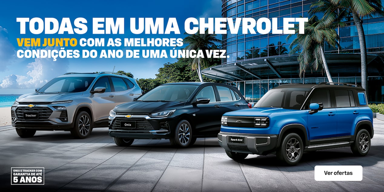 Três veículos Chevrolet - Tracker, Onix e Spark - estão estacionadas em frente a um moderno edifício de vidro, com palmeiras e o oceano ao fundo. O texto anuncia condições especiais e garantia de 5 anos.