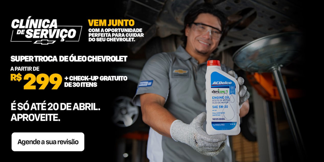 Um mecânico segura uma garrafa de óleo de motor em uma oficina mecânica. O texto promocional oferece troca de óleo Chevrolet a partir de R$ 299 e revisão gratuita de 30 itens até 20 de abril.