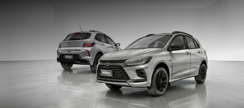  Visão lateral do Onix Activ Prata. São dois veículos, cada um com um ângulo lateral: um com foco na traseira e lateral direita, destacando o rack de teto e lanternas; outro de frente e lateral esquerda, com destaque para a grade, rodas e logo da Chevrolet. Acima da imagem, temos a legenda: Em breve. Onix Activ: presença e atitude para ir além. Botão clicável com o texto: comprar agora!