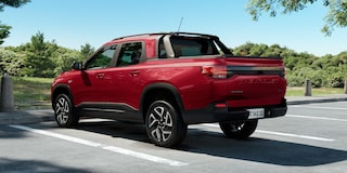 Vista traseira da Chevrolet Montana na cor Vermelho Scarlet estacionada em ambiente arborizado e ensolarado