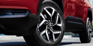 Rodas de liga leve da Chevrolet Montana na cor Vermelho Scarlet com fundo de piso asfáltico