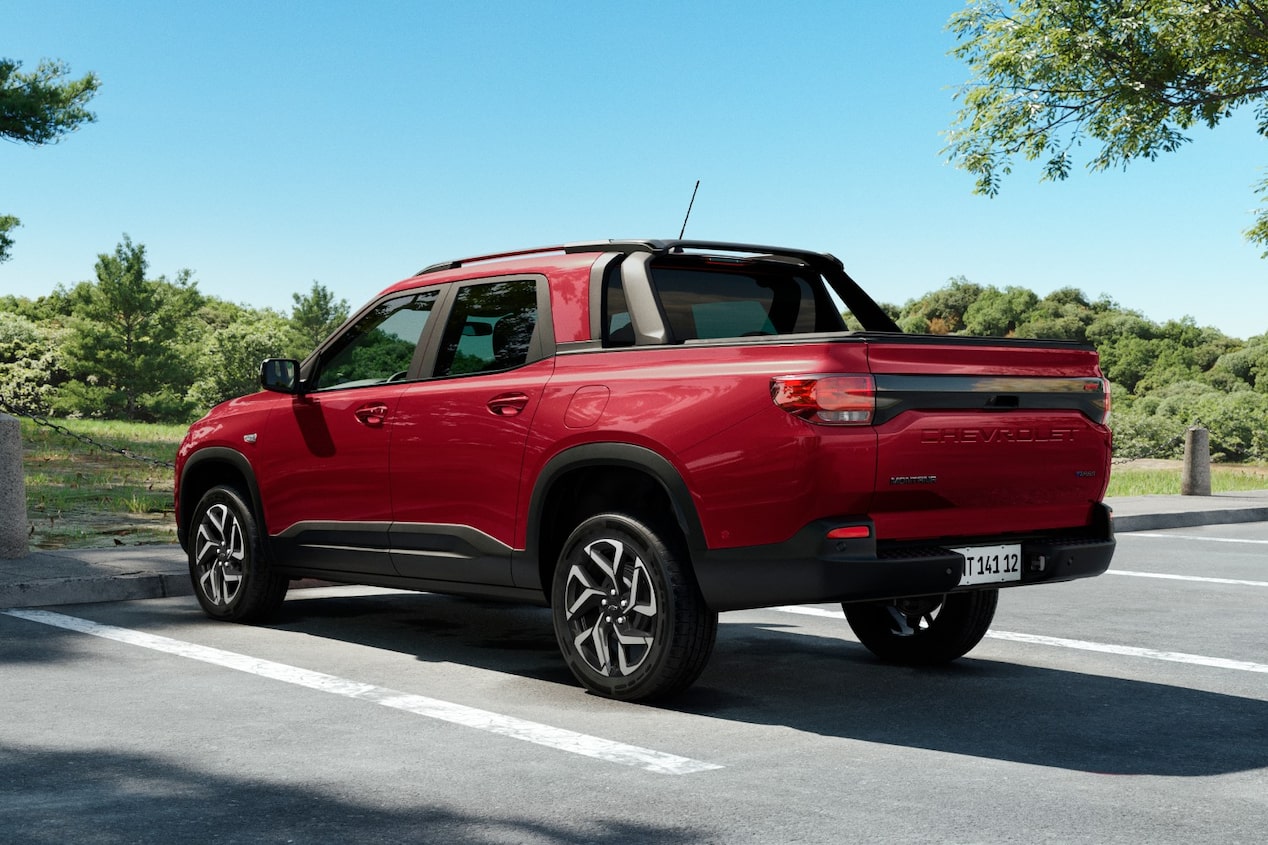 Vista traseira da Chevrolet Montana na cor Vermelho Scarlet estacionada em ambiente arborizado e ensolarado