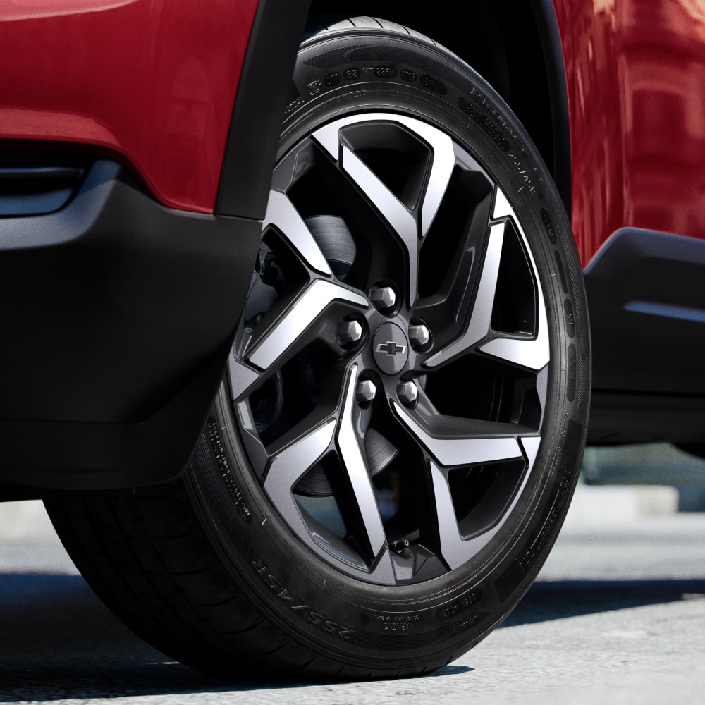 Rodas de liga leve da Chevrolet Montana na cor Vermelho Scarlet com fundo de piso asfáltico
