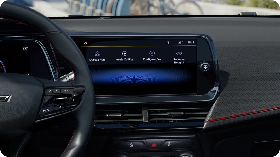 Painel e interior da Chevrolet Montana com acabamento escurecido, vista da direção com fundo urbano claro.