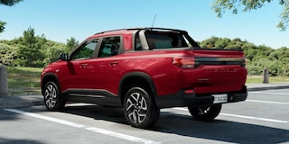 Vista traseira da Chevrolet Montana na cor Vermelho Scarlet estacionada em ambiente arborizado e ensolarado