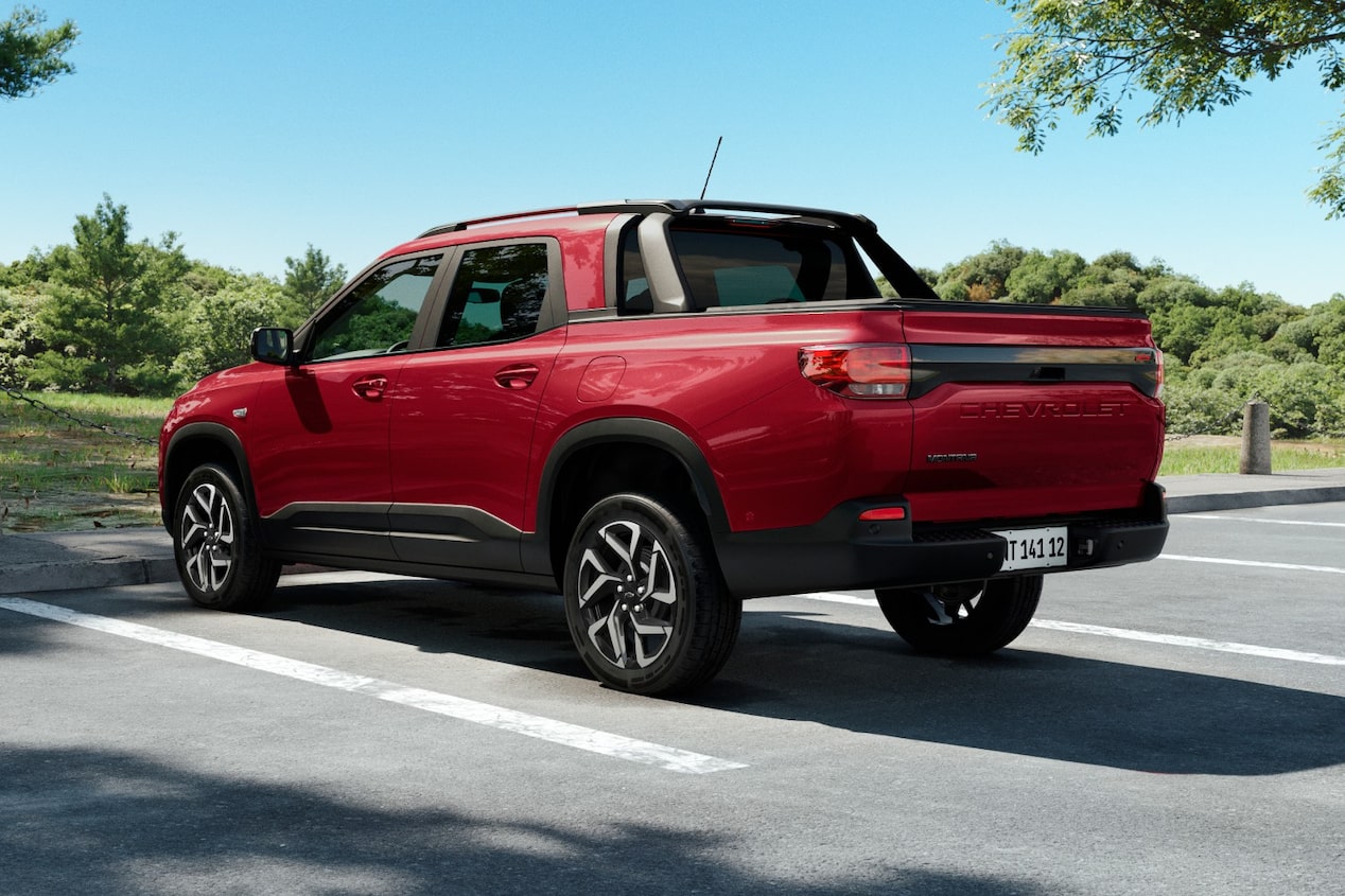 Vista traseira da Chevrolet Montana na cor Vermelho Scarlet estacionada em ambiente arborizado e ensolarado