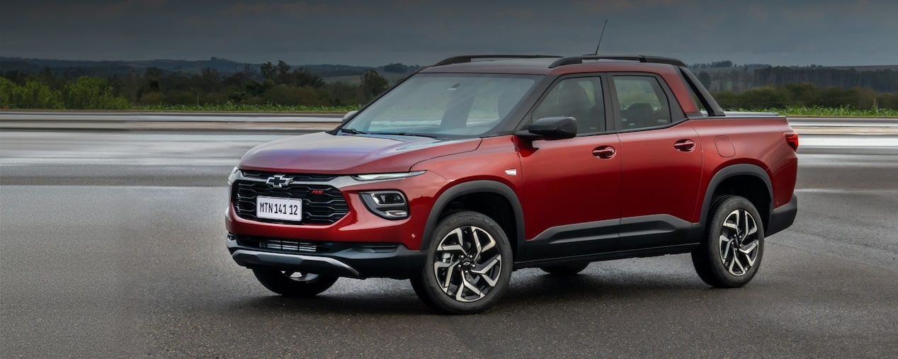 Chevrolet Montana vermelha estacionada para compor o banner principal da página. No quadrante superior esquerdo, o texto: 2027 - Montana, no quadrante inferior direito, o botão: comprar agora.