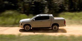 Chevrolet S10 levantando poeira enquanto corre em uma estrada de terra. Ao fundo, uma paisagem com vegetação e árvores