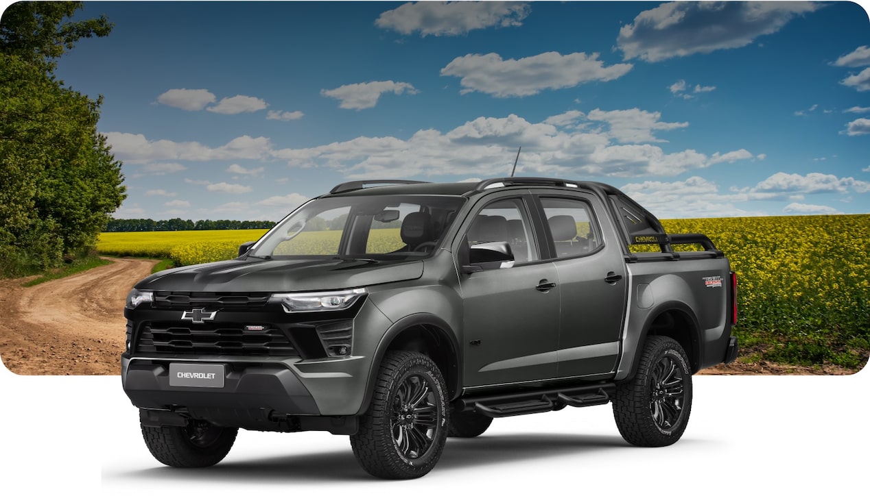 Chevrolet S10 Trail Boss em perspectiva. Vemos a lateral esquerda e toda parte frontal do modelo. Ao fundo uma paisagem rural