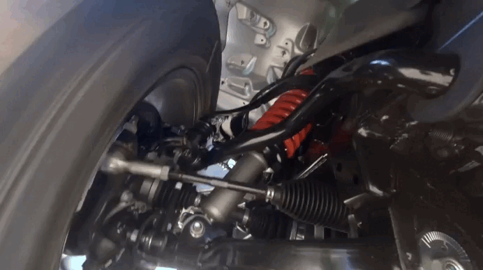 Imagem focada na suspensão da Chevrolet S10 Trail Boss. A foto foi tirada da parte de baixo do carro com ele em movimento. Vemos a roda, tal como a suspensão exclusiva Ironman