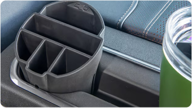 Imagem do interior da nova picape Chevrolet Silverado, destacando os acessórios organizador e porta copos.