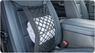 Imagem do interior da nova picape Chevrolet Silverado, destacando o acessório rede de proteção para bancos, localizado no encosto do banco do passageiro.