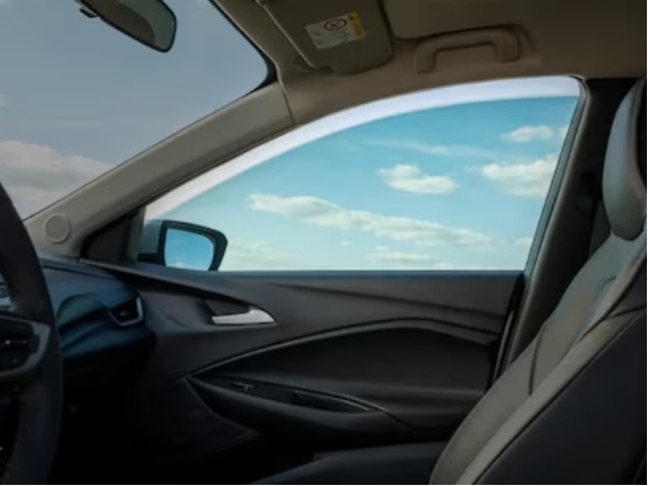 Imagem mostrando o interior do carro, destacando o acessório \"película de vidro\", instalado na janela do passageiro.