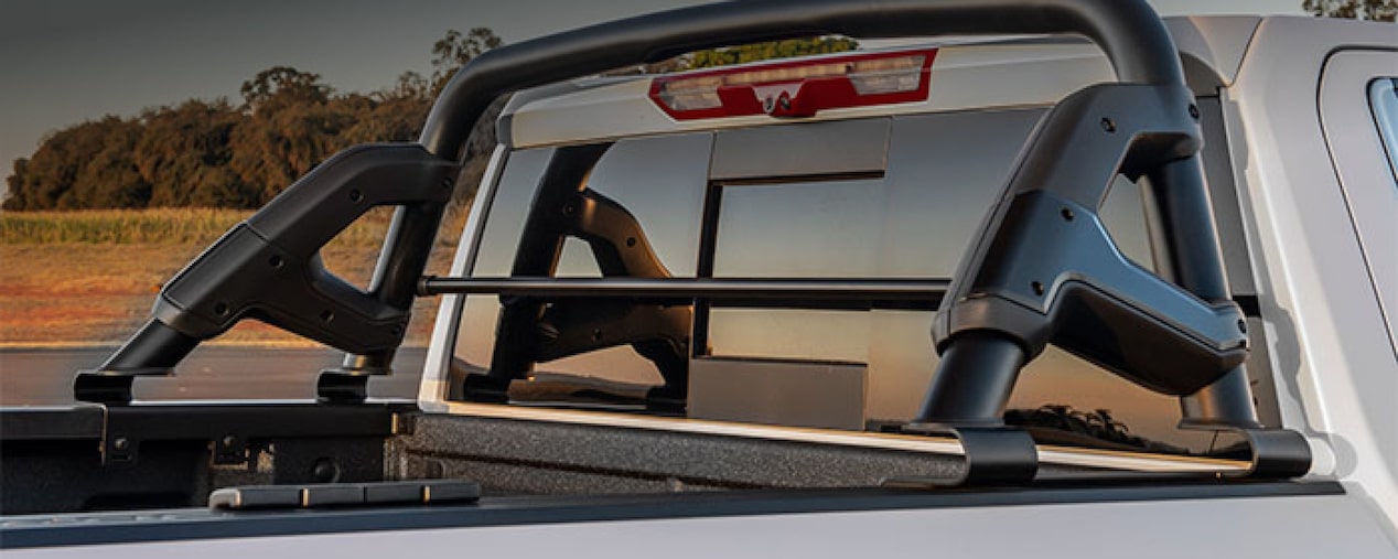 Mastehead da página de Racks e suportes dos acessórios originais Chevrolet para a picape Silverado, que aparece em imagem ambientada no campo.