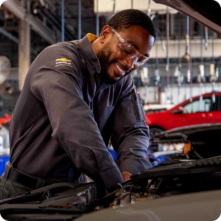 Mecânico fazendo a manutenção do motor de um Chevrolet