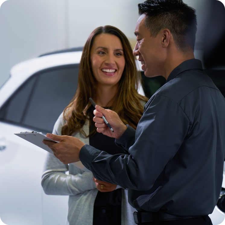 Mulher falando com homem de concessionária