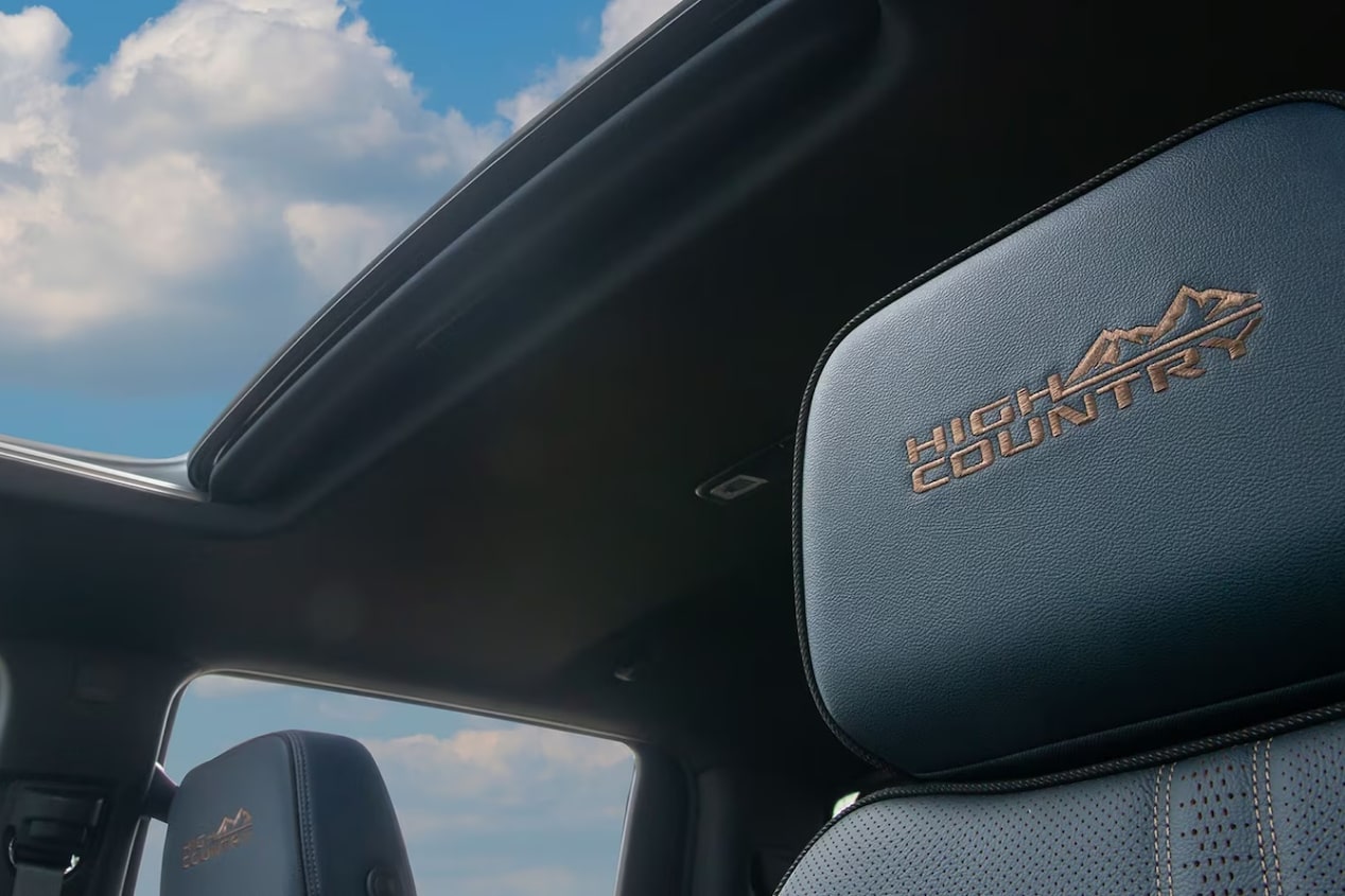 Vista do encosto das poltronas da Silverado, com a visão do teto solar do veículo. 