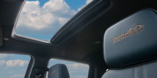 Vista do encosto das poltronas da Silverado, com a visão do teto solar do veículo. 