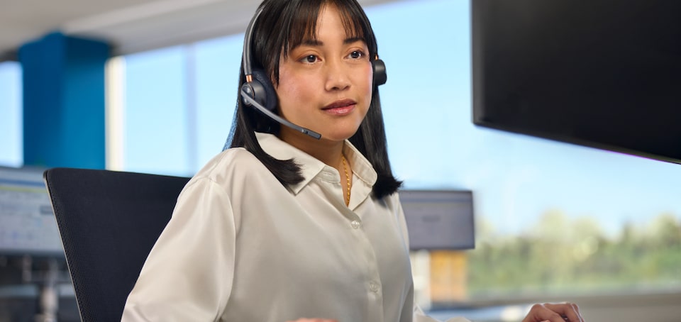 Imagem de atendimento ao cliente com profissional utilizando headset em ambiente corporativo, ilustrando os canais de suporte e relacionamento do GM Rewards.