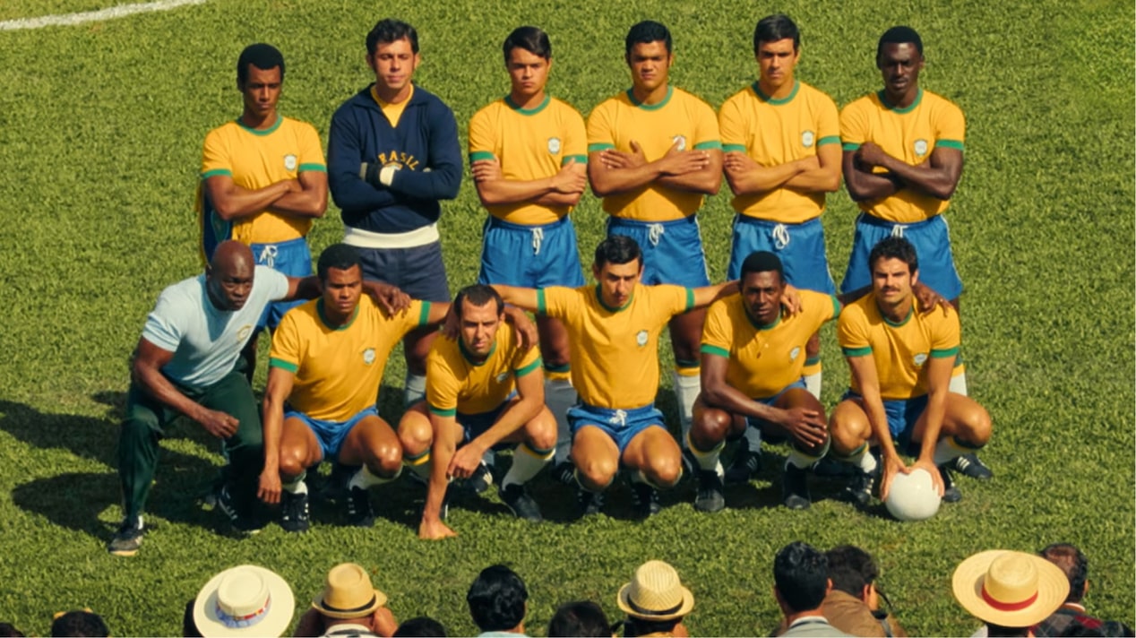 Time de futebol com uniforme clássico do Brasil posando em campo durante campanha promocional Chevrolet com parceria Netflix