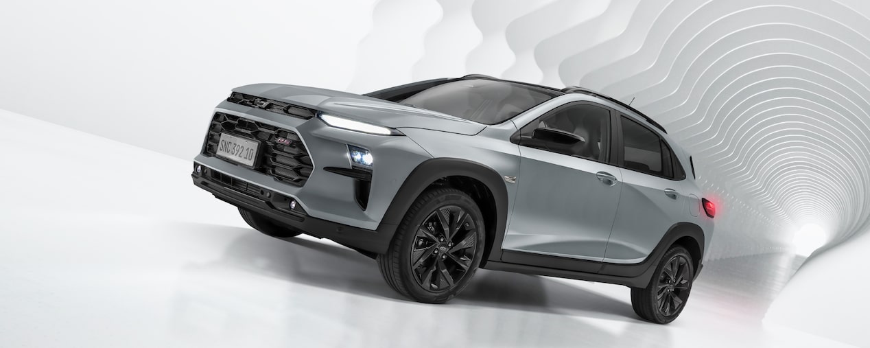 Chevrolet Sonic 2027 estacionado em um ambiente todo branco. Os detalhes em preto do carro e nas rodas se destacam no fundo claro. Imagem feita para compor banner principal da página. No quadrante superior esquerdo.