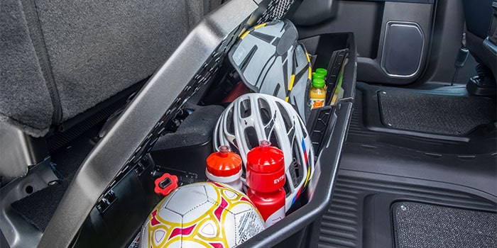 Imagem do interior da nova picape Chevrolet Silverado, destacando compartimento organizador localizado sob o assento.