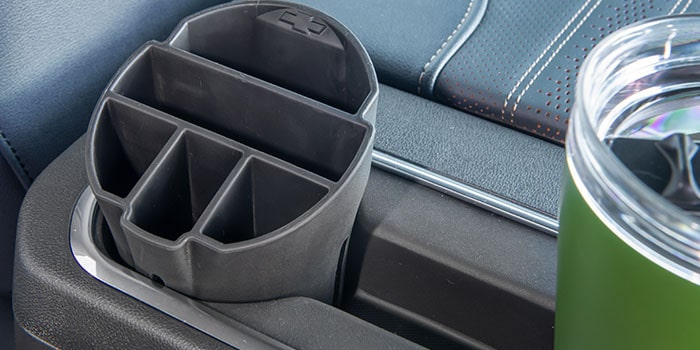 Imagem do interior da nova picape Chevrolet Silverado, destacando os acessórios organizador e porta copos.