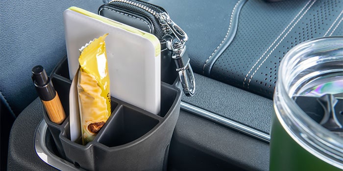 Imagem do interior da nova picape Chevrolet Silverado, destacando os acessórios organizador e porta copos.