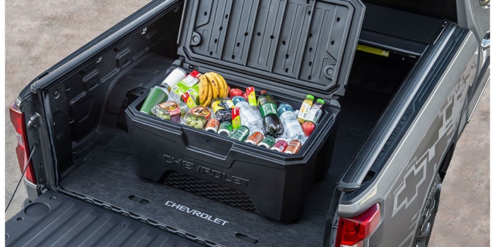 Imagem mostrando caçamba da nova picape Chevrolet Silverado, destacando o acessório "caixa organizadora térmica de caçamba de 150 litros" cheia de garrafas.